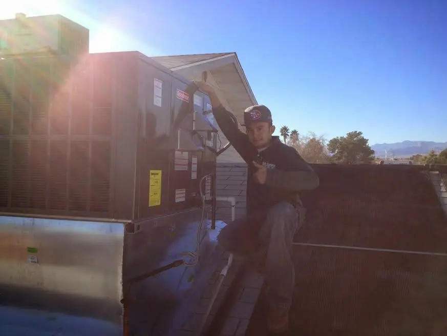 HVAC technician performing Boiler Repair on a rooftop unit in Long Beach
